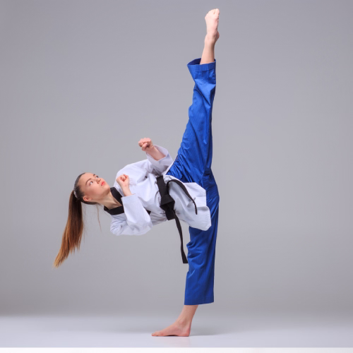 Adolescente realizando una patada en una clase de artes marciales en Madrid dentro de una escuela
