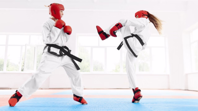 Grupo de adolescentes entrenando taekwondo con kimono sobre tatami en una escuela y academia en Madrid