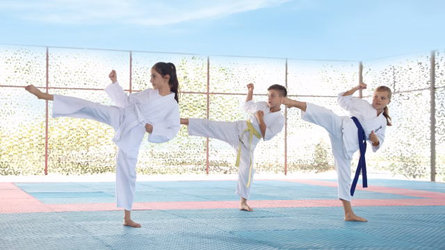 Grupo de niños entrenando taekwondo infantil con kimono sobre tatami en una escuela y academia en Madrid